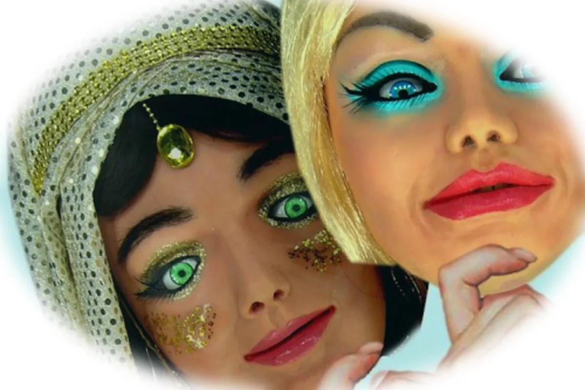 Primo piano di due volti animatronici con trucco degli occhi verde e turchese